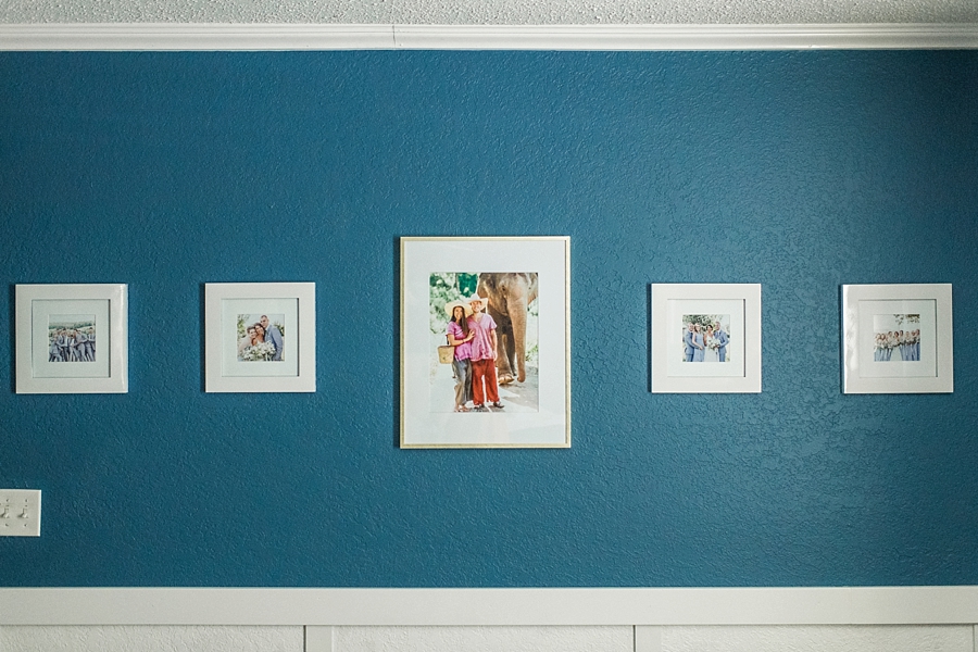 Why You Should Print Your Photos | White frames on a navy blue wall in bedroom